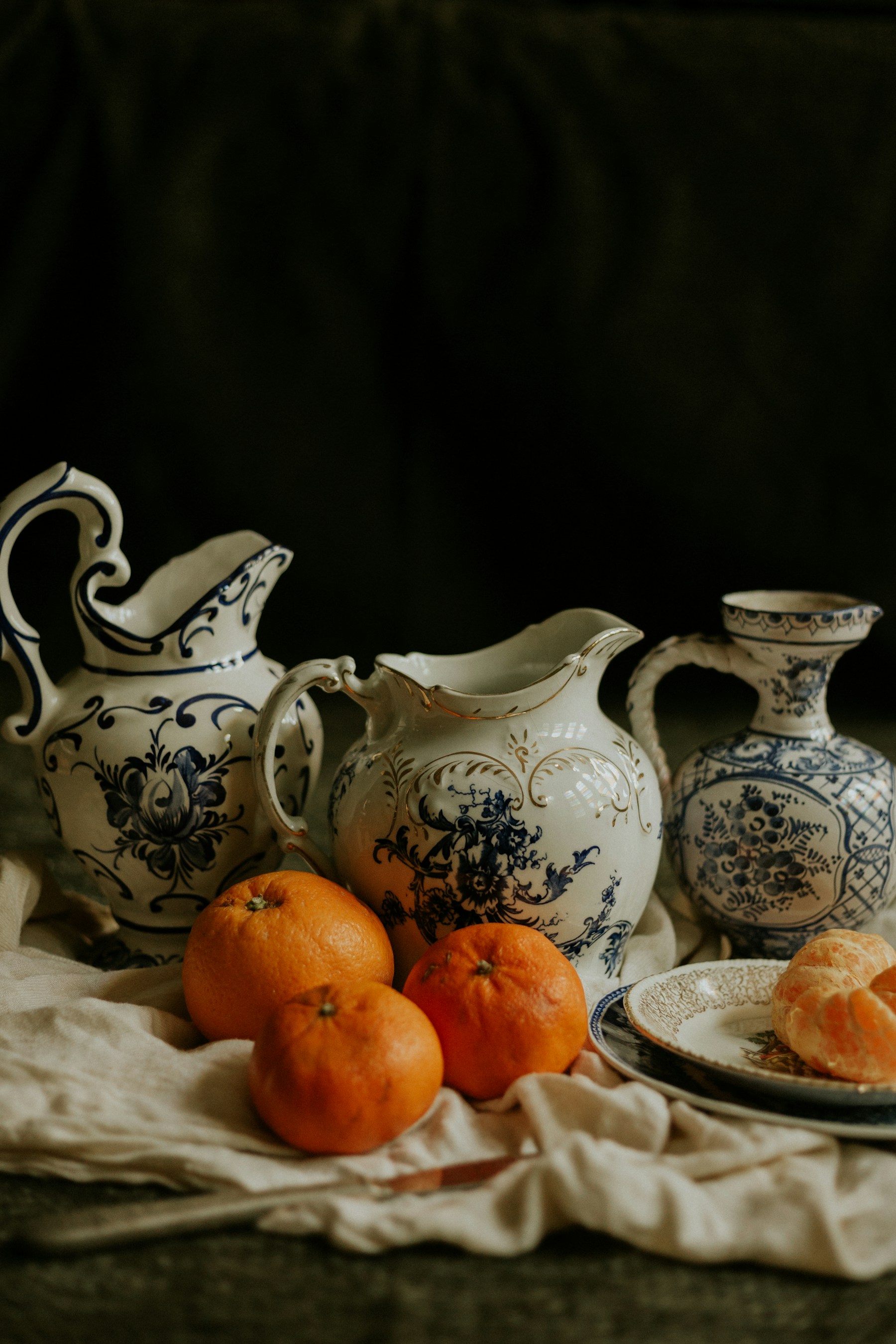 Blue and white ceramic pitchers with fresh oranges