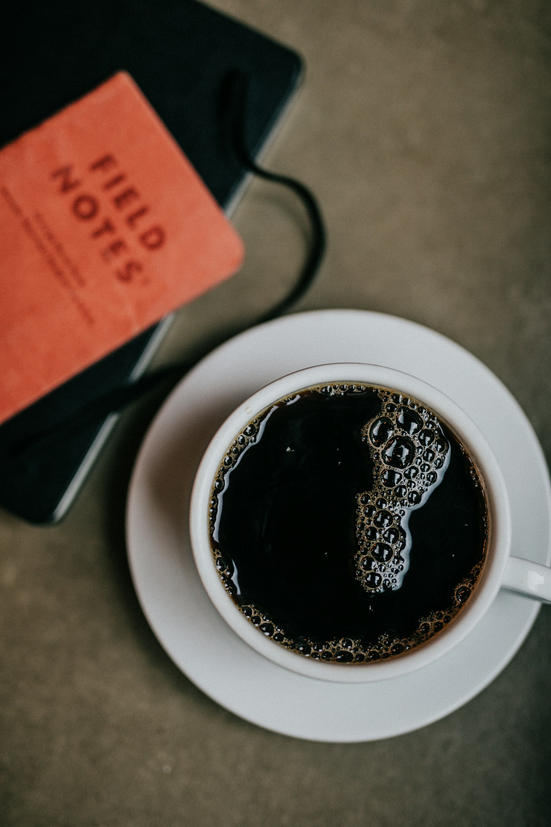 Overhead photograph of a white cup filled with dark coffee